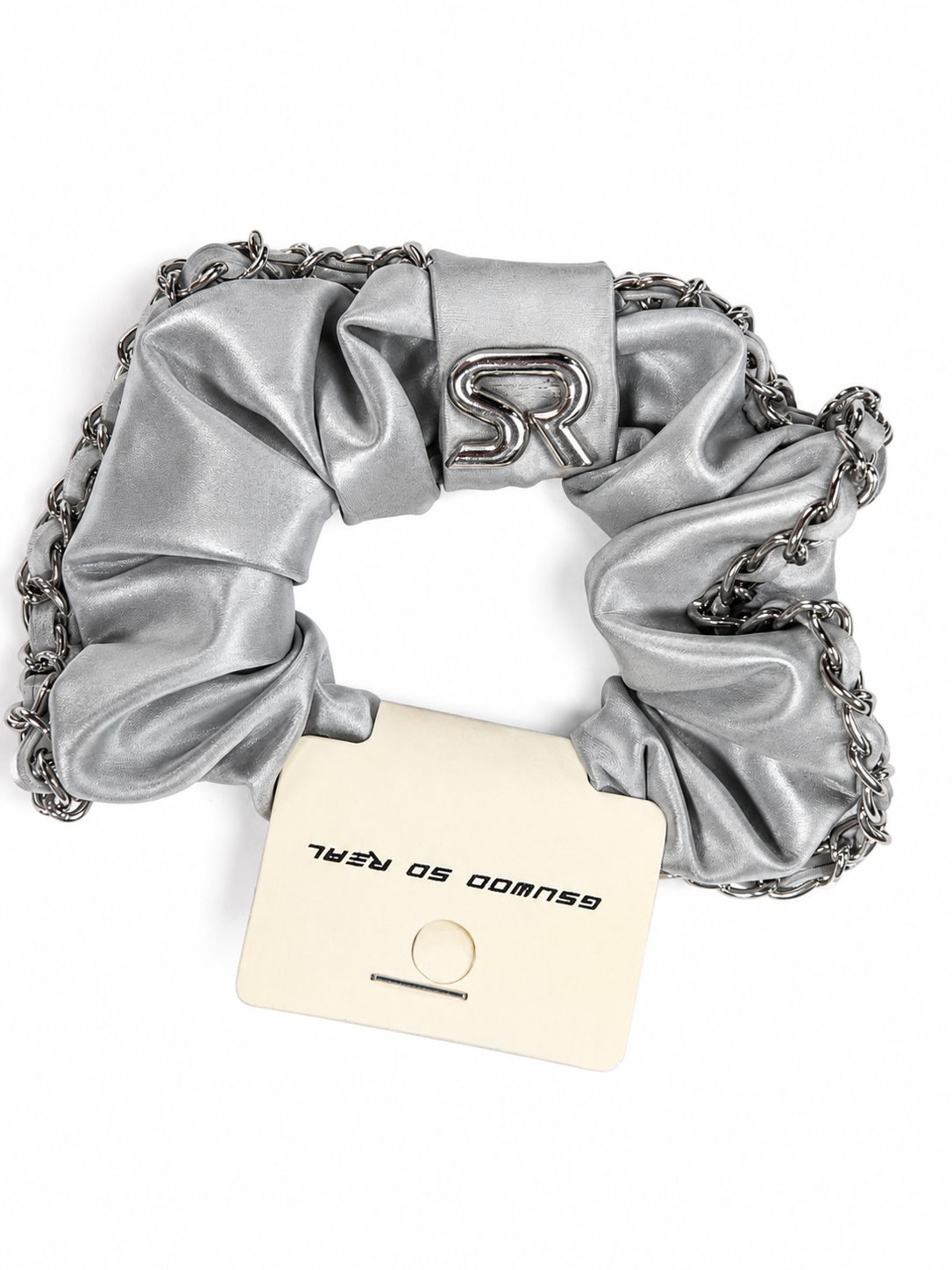 Silver scrunchie with chain detail and a card on a white background